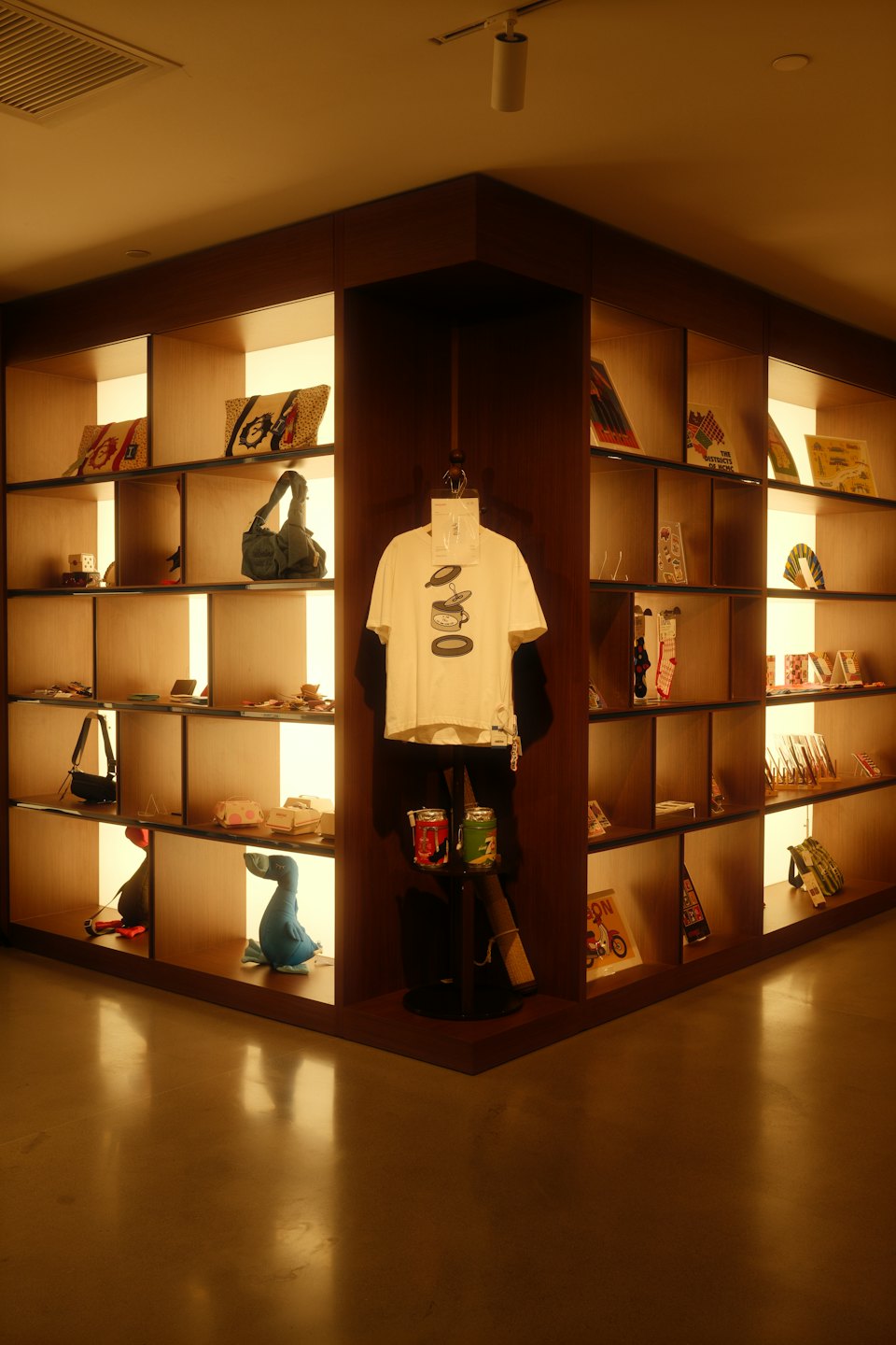 Modern retail display with backlit shelves and hanging t-shirt.